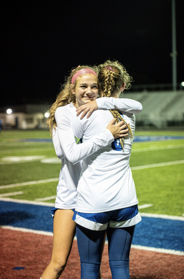 Reese Wilkens (11) hugs Kendall Graves (12) after an exciting game. 